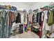 Walk-in closet with lots of clothing hung up and racks for shoes and storage at 13529 Wild Ginger St, Riverview, FL 33579