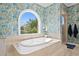 Bright bathroom with soaking tub under arched window and glass-enclosed shower at 136 W Davis Blvd, Tampa, FL 33606