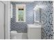 Stylish bathroom with patterned wallpaper, modern fixtures, a window, and white tile flooring at 136 W Davis Blvd, Tampa, FL 33606