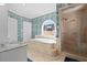 Bright bathroom with soaking tub under arched window and glass-enclosed shower at 136 W Davis Blvd, Tampa, FL 33606