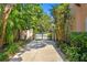 Private driveway leading to a gated entrance, lined with mature landscaping for a secluded feel at 136 W Davis Blvd, Tampa, FL 33606