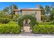 A home with a tile roof framed by an arched gate covered in climbing vines at 136 W Davis Blvd, Tampa, FL 33606