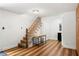 Hallway featuring a staircase, modern table, wood floors, and access to multiple rooms at 136 W Davis Blvd, Tampa, FL 33606