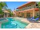 Beautiful backyard pool with a covered patio, lounge chairs, and manicured landscaping perfect for outdoor living at 136 W Davis Blvd, Tampa, FL 33606
