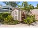 Outdoor storage shed, with painted wood and decorative door, surrounded by lush tropical foliage at 136 W Davis Blvd, Tampa, FL 33606