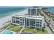 An aerial view of a beachfront condo building showcasing balconies, beach access, and a swimming pool at 1400 Gulf Blvd # 306, Clearwater Beach, FL 33767