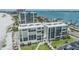 An aerial view of a beachfront condo building featuring multiple balconies and well-maintained landscaping at 1400 Gulf Blvd # 306, Clearwater Beach, FL 33767
