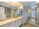 Bathroom featuring mirrored walls, vanity with single sink, and tiled shower at 1400 Gulf Blvd # 306, Clearwater Beach, FL 33767