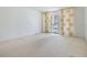 Bright, carpeted bedroom with sliding door to the balcony and light-filtering curtains at 1400 Gulf Blvd # 306, Clearwater Beach, FL 33767