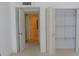 Bright bedroom has open closet with shelving and view to the hallway at 1400 Gulf Blvd # 306, Clearwater Beach, FL 33767