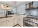 Bright kitchen featuring white cabinets, stainless steel appliances, and mirrored backsplash at 1400 Gulf Blvd # 306, Clearwater Beach, FL 33767