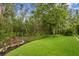 Lush backyard featuring a designated green space and well-maintained landscaping, offering a private outdoor sanctuary at 14851 Tudor Chase Dr, Tampa, FL 33626