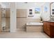 Bright bathroom featuring a soaking tub, a glass-enclosed shower, and ceramic tile flooring at 14851 Tudor Chase Dr, Tampa, FL 33626