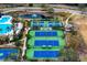 Aerial view of community amenities with tennis courts, a pond with a fountain, and lush landscaping at 14851 Tudor Chase Dr, Tampa, FL 33626