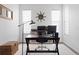 Bright home office with modern black desk, woven basket, and two windows providing plenty of natural light at 14851 Tudor Chase Dr, Tampa, FL 33626