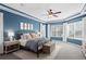 Main bedroom with tray ceiling, large windows, and en-suite bath access at 14851 Tudor Chase Dr, Tampa, FL 33626