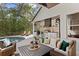 Outdoor kitchen featuring stainless steel appliances, dark countertops, a grill, and comfortable seating with a view of the pool at 14851 Tudor Chase Dr, Tampa, FL 33626