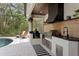 Outdoor kitchen featuring stainless steel appliances, a grill, and counter space for outdoor cooking and dining at 14851 Tudor Chase Dr, Tampa, FL 33626