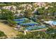 Aerial view of community tennis and pickleball courts surrounded by green space and neighborhood housing at 14851 Tudor Chase Dr, Tampa, FL 33626