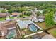 An aerial view displays the backyard pool, and landscaped houses surrounded by green trees at 1624 Shady Leaf Dr, Valrico, FL 33596