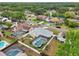 An aerial view shows the backyard pool and landscaped houses in a residential neighborhood at 1624 Shady Leaf Dr, Valrico, FL 33596