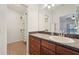 Bathroom featuring a single sink vanity with wood cabinets, closet, and a large mirror at 1624 Shady Leaf Dr, Valrico, FL 33596