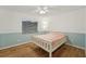 Comfortable bedroom features hardwood floors, a ceiling fan, and a window with bright natural light at 1624 Shady Leaf Dr, Valrico, FL 33596