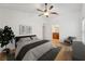 Staged bedroom featuring wood-look floors, ceiling fan, ensuite bathroom, and accent furniture at 1624 Shady Leaf Dr, Valrico, FL 33596