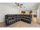 Spacious living room featuring an L shaped sectional sofa, tile flooring, and ceiling fan at 1624 Shady Leaf Dr, Valrico, FL 33596