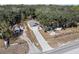 Aerial view of home featuring a long driveway, fenced yard, and a mix of cleared and wooded land at 16519 Us Highway 41, Spring Hill, FL 34610