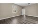 Neutral colored bedroom with grey wood floors and an adjoining doorway at 16519 Us Highway 41, Spring Hill, FL 34610