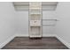 Walk in closet with shelves and grey wood floors at 16519 Us Highway 41, Spring Hill, FL 34610