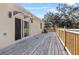 Spacious wooden deck with a light wood railing, accessible via sliding glass door under a protective awning at 16519 Us Highway 41, Spring Hill, FL 34610