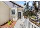 A beautifully landscaped front entrance showcases a modern door with decorative glass and white railing along a walkway at 16519 Us Highway 41, Spring Hill, FL 34610