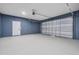 Spacious garage features a painted blue wall, side entry, and garage door at 16519 Us Highway 41, Spring Hill, FL 34610