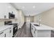 Stylish kitchen includes stainless steel appliances, an island with a sink, and an open layout flowing into the living area at 16519 Us Highway 41, Spring Hill, FL 34610