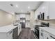 The kitchen features modern appliances, white cabinets, an island with a sink, and sleek countertops, enhancing functionality at 16519 Us Highway 41, Spring Hill, FL 34610