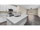 Modern kitchen featuring white cabinets, stainless steel appliances, and a spacious island with quartz countertops at 16519 Us Highway 41, Spring Hill, FL 34610