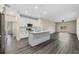 Open-concept kitchen features a large island, white cabinets, stainless steel appliances, and luxury vinyl plank flooring at 16519 Us Highway 41, Spring Hill, FL 34610