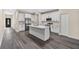 Bright kitchen features a central island, stainless appliances, sleek white cabinets, and dark wood-look floors at 16519 Us Highway 41, Spring Hill, FL 34610