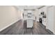 A long view showing open floor plan with a kitchen island, appliances, and modern grey wood flooring at 16519 Us Highway 41, Spring Hill, FL 34610