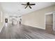 Open-concept living area with sleek grey wood flooring, and a view into kitchen at 16519 Us Highway 41, Spring Hill, FL 34610