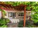 Inviting back patio with a wood pergola, stone accents, and manicured landscaping at 2008 Berry Lake Dr, Brandon, FL 33510