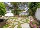 Spacious backyard with stone walkway, lush greenery, and mature trees at 2008 Berry Lake Dr, Brandon, FL 33510