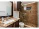 Bathroom featuring granite counter, dark wood cabinets, sink, toilet and tiled glass shower at 2008 Berry Lake Dr, Brandon, FL 33510