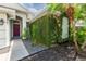 Stylish front entry featuring a red door and mature greenery on the facade at 2008 Berry Lake Dr, Brandon, FL 33510