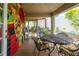 Covered patio area with tile floors, metal table, chairs and a colorful painted brick wall at 2008 Berry Lake Dr, Brandon, FL 33510