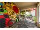 Covered patio area with tile floors, metal table, chairs and a colorful painted brick wall at 2008 Berry Lake Dr, Brandon, FL 33510
