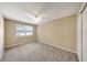 Relax in this bedroom with plush carpet, natural light, and a ceiling fan for added comfort at 2048 Los Lomas Dr, Clearwater, FL 33763