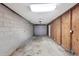 Unfinished garage with block walls, overhead lighting, and a roll-up garage door at 2048 Los Lomas Dr, Clearwater, FL 33763